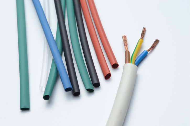 heat shrink tubing and a three-core stripped wire on a white background. high temperature tubing and three-core stripped wire on a white background